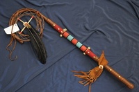 Native American dance sticks and dancing have always formed a central part of Native American tribal life. There are quite a few elements that go into a successful dance. Music from drums and flutes, of course, is very important. However, Native American dance sticks are also integral to different dances. These decorated dance sticks add a visual touch to the dance, and are specific to the ceremony. American Indians use dances for healing, to honor the fallen, and in times past, when going on the warpath. Dance sticks were made for each of these ceremonies. Nearly every Native American tribe made dance sticks. Dance sticks were made for specific purposes within each individual tribe. Dance sticks are generally made of a length of wood with a section of antler on one or both ends. Prayers that are being sent to the Great Spirit are represented by particular feathers used. Representative of a tribe or individual, the colors used for a dance stick are chosen carefully. Animal skulls were sometimes used to embellish the dance sticks. Being passed down throughout generations, Native American dance sticks are sometimes heirlooms. Although Indian dance sticks were used for war dances, there was another very important purpose. These sticks were used to honor a departed horse. The bond between the Native American and his horse was a strong one, and not even death could sever it completely. When preparing the dance stick for the tribute to the horse, an additional decoration was added. Hair from the horse's tail or mane was used to embellish the stick in order to ensure that the prayers of the warrior were directed to the horse. The healing ceremony is still a vital part of Native American tribal life. To better direct the healing energies, a shaman or medicine man will often use a dance stick. The decorations on the stick have all been chosen for specific beneficial properties. A shaman will use a dance stick for both a healing dance and meditation. Sometimes a medicine bag was attached to a healing dance stick as well. Used for meditation as well as dancing, the Native American dance stick can be enjoyed by anyone. These beautifully decorated sticks will also add a natural touch to any room's decor. The bright colors and detailed decorations will make these dance sticks a treasured addition to the home. They will go perfectly with country decor as well as Southwest style decorating. A cabin or vacation home can be cheered and brightened by a display of dance sticks and they can add a touch of color and interest to a minimalist modern setting as well. View our complete Native American Dance Sticks gallery.